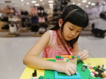 Full length of girl looking at table