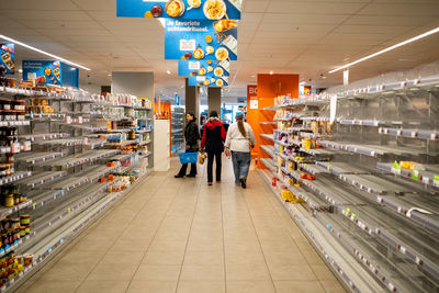 Rear view of people standing in illuminated store