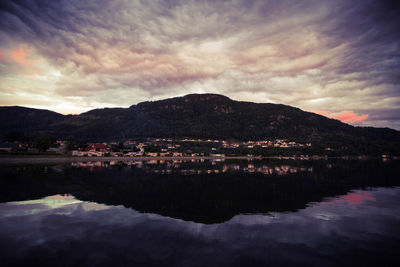 Scenic view of lake by buildings against sky