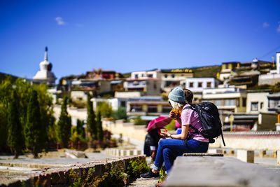 Rear view of couple on cross against clear sky