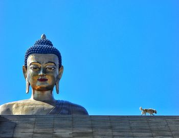 Low angle view of statue against clear blue sky