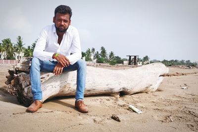 Portrait of young man sitting on land