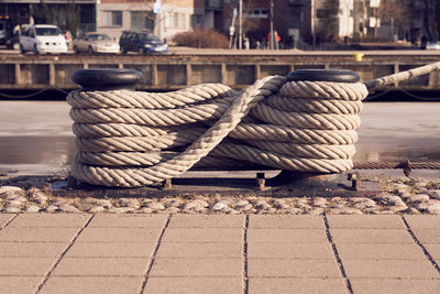Close-up of rope tied to wooden post in harbor