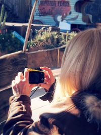 Midsection of woman photographing with mobile phone