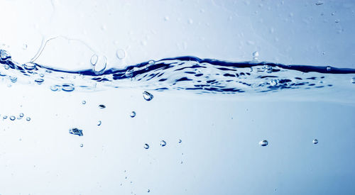 Close-up of water splashing against blue background