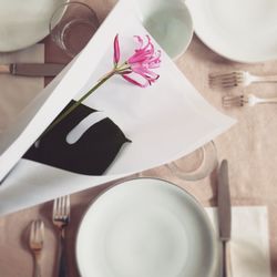 High angle view of hand holding paper on table