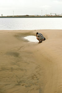 Boy on beach against sky