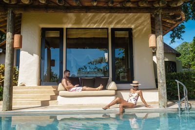 Side view of woman sitting in swimming pool