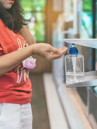Midsection of woman holding ice cream in glass