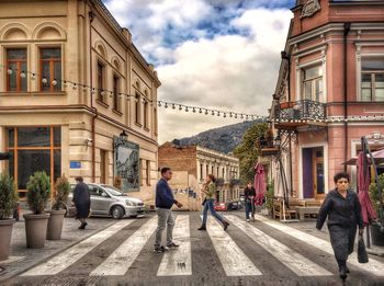 People walking on road along buildings