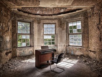 Empty chairs and table in abandoned building