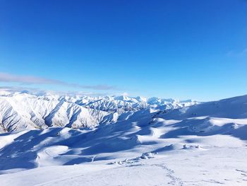 Scenic view of snowcapped mountains against clear blue sky