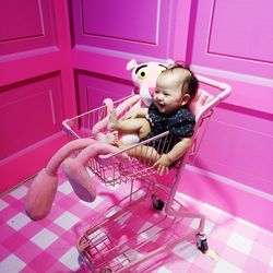 Cute baby girl sitting in shopping cart