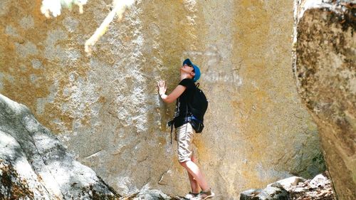 High angle view of young woman standing by wall