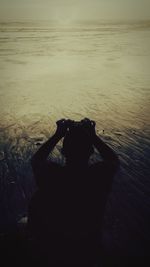 Rear view of woman photographing against sky