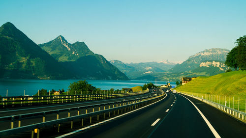 Road by mountains against clear sky