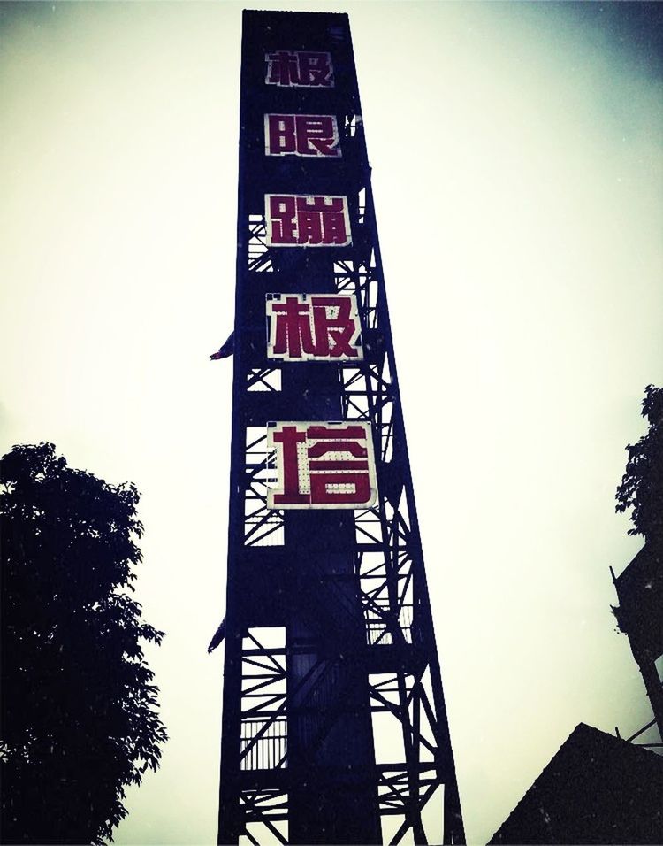 low angle view, text, communication, western script, built structure, architecture, tree, building exterior, clear sky, sky, guidance, information sign, road sign, sign, capital letter, information, non-western script, no people, outdoors, directional sign