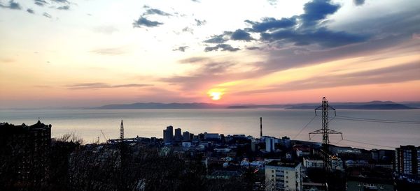 High angle view of townscape by sea against sky during sunset