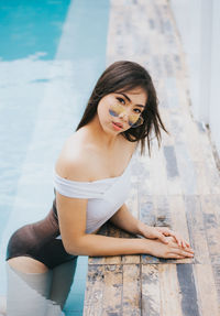 High angle portrait of sensuous woman wearing swimsuit in pool