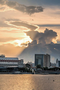 Scenic view of sea and buildings against sky during sunset