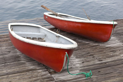 Two red rowboat on wood bridge