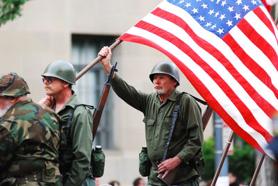 Full length of man holding flag standing outdoors