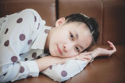 Portrait of cute baby lying on bed at home