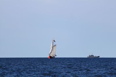 Boat sailing in sea against clear sky