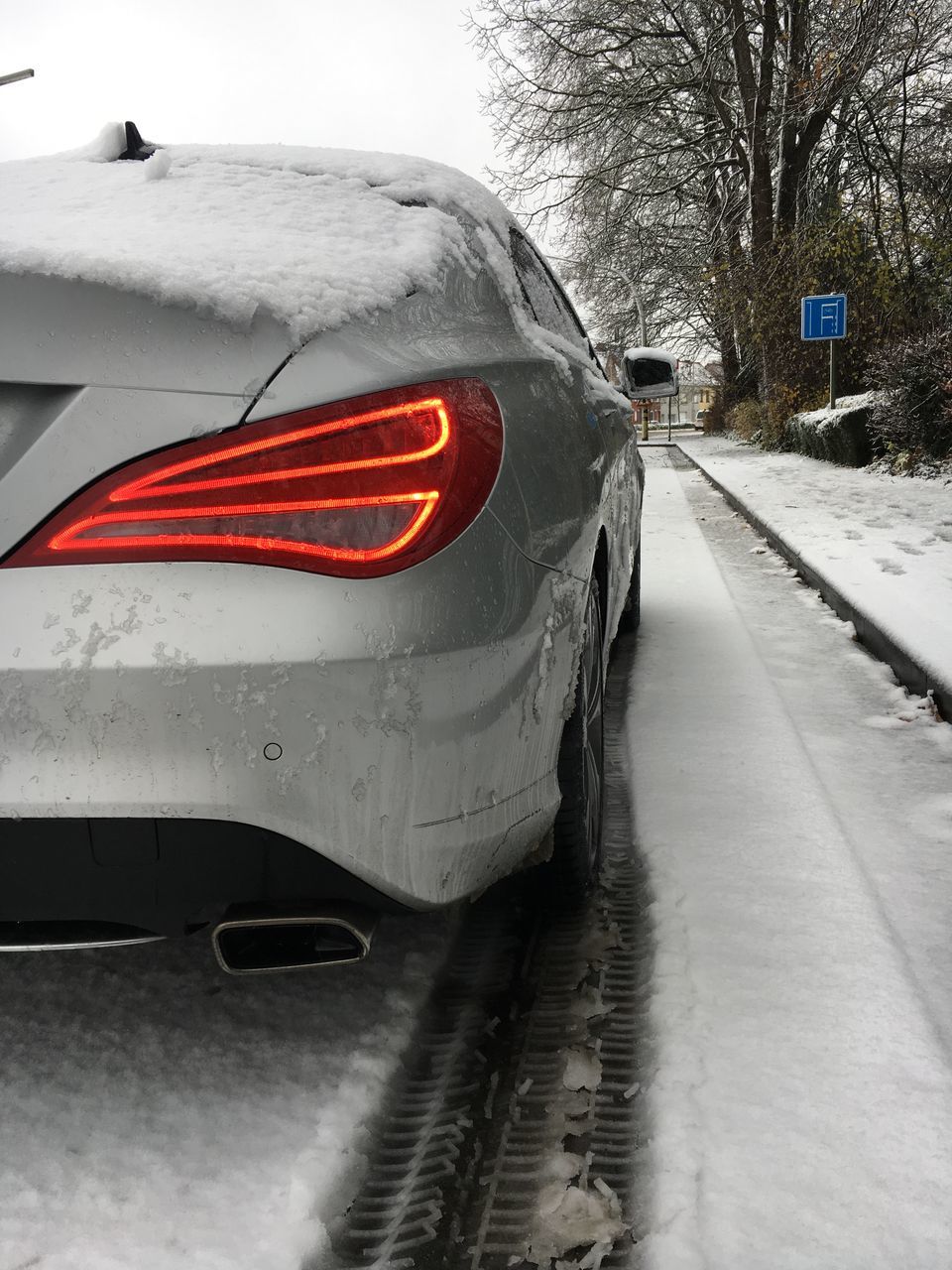 CLOSE-UP OF FROZEN CAR ON SNOW COVERED ROAD