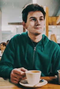 Portrait of young man drinking coffee