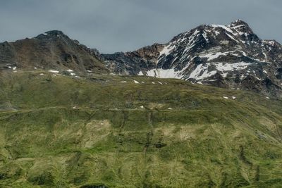 Scenic view of land and mountains against sky