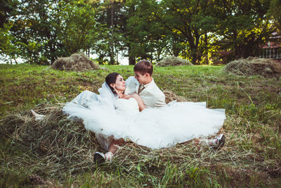 Full length of couple sitting at park