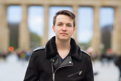 Portrait of confident young man standing at brandenburg gate