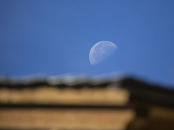 Low angle view of moon against blue sky