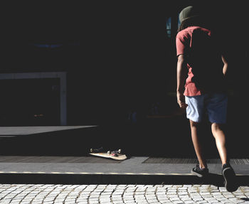 Low section of man standing on tiled floor