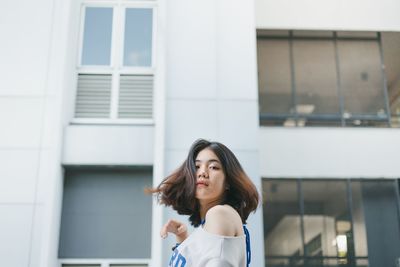 Portrait of woman standing against building