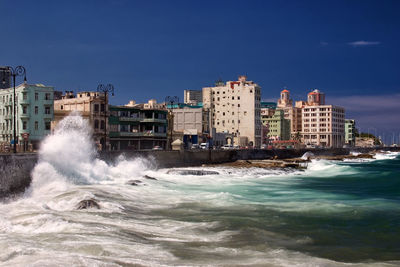 Water flowing by sea against sky in city