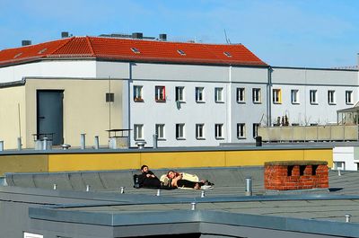 People in front of building against clear sky