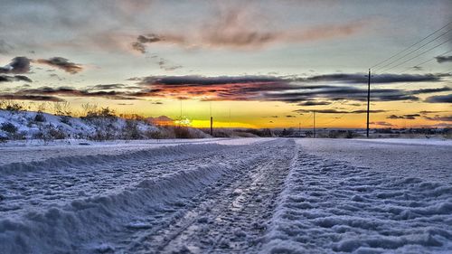 Scenic view of snow covered landscape against dramatic sky