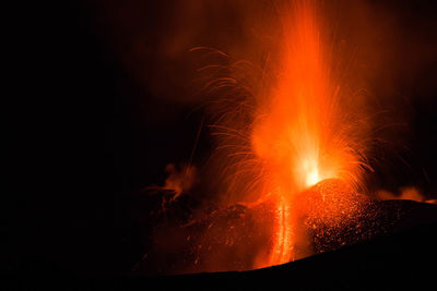 Etna volcano eruption with lava flow and great explosion from top crater at night- sicily adventures