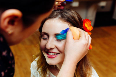 Cropped image of artist painting face during birthday