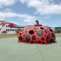 Red umbrella on tiled floor against sky