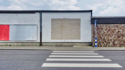 Road by building against sky