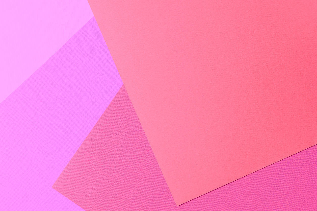 HIGH ANGLE VIEW OF MULTI COLORED PAPER ON PINK BACKGROUND