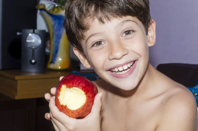 Child eating red apple at home. 