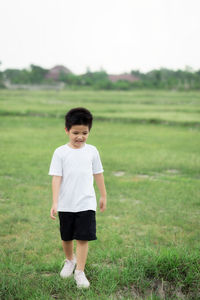 Full length of boy standing on field