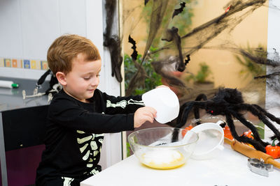 Close-up of boy playing with dog at home