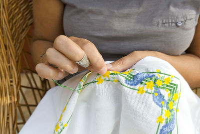 Midsection of woman embroidering on fabric
