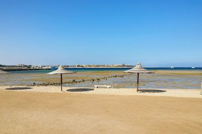 Scenic view of beach against clear blue sky