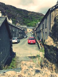 Cars on road by mountain against sky